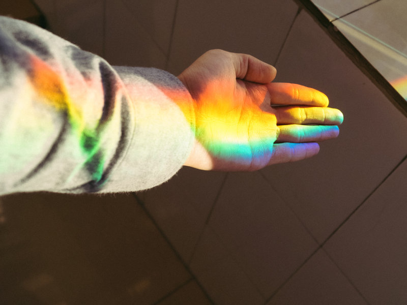 Image of a hand with a play of light in rainbow colors