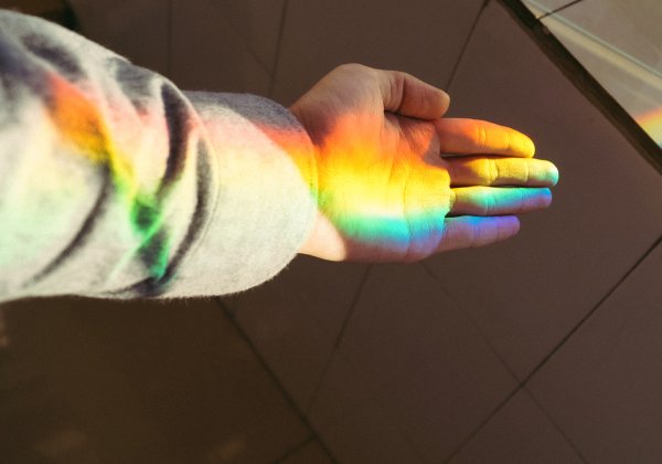 Bild einer Hand mit einem Lichtspiel in Regenbogenfarben
