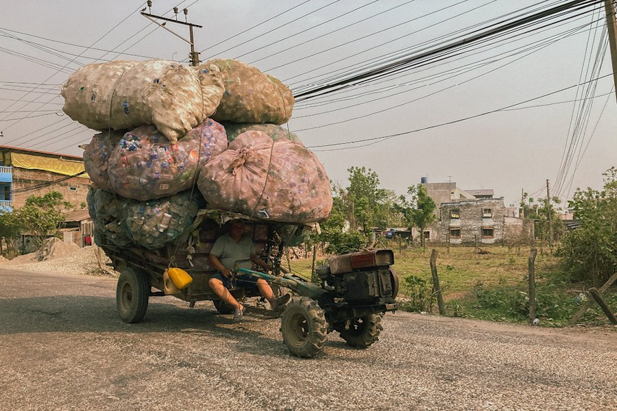Man on a bike who transports a lot of plastic.