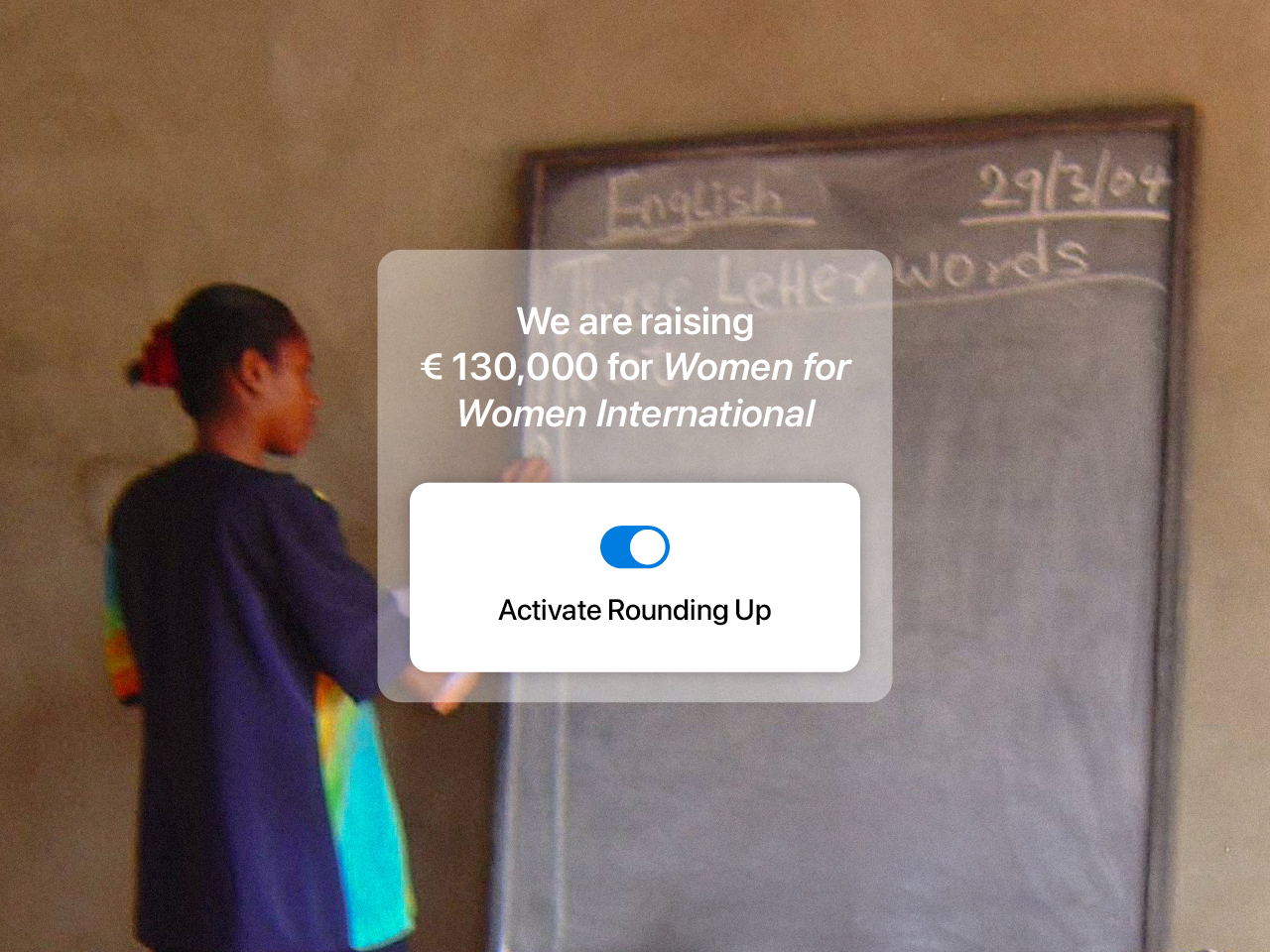 You can see a woman from the supported program. She is standing at a blackboard and writing.