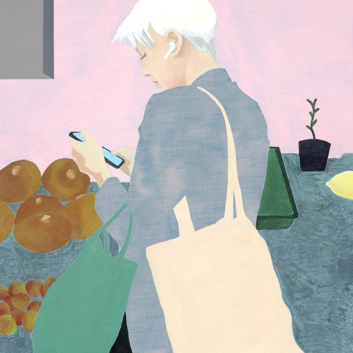 A woman with white hair looking on her mobile phone and carrying shopping bags on her shoulder