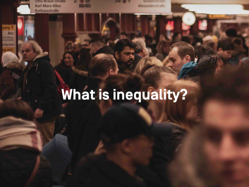 Photo of crowded train station with text "what is inequality" on it