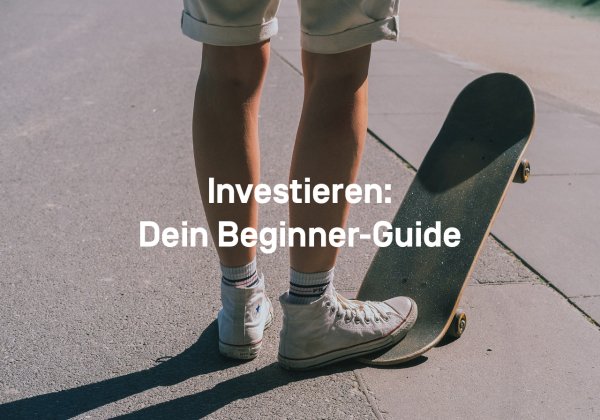 Ein junger Mann in kurzer Hose und Chucks steht auf der Straße. Sein rechter Fuß steht auf dem hinteren Teil eines Skateboards, die vorderen Rollen schweben in der Luft. 
Text: Investieren: Dein Beginner-Guide