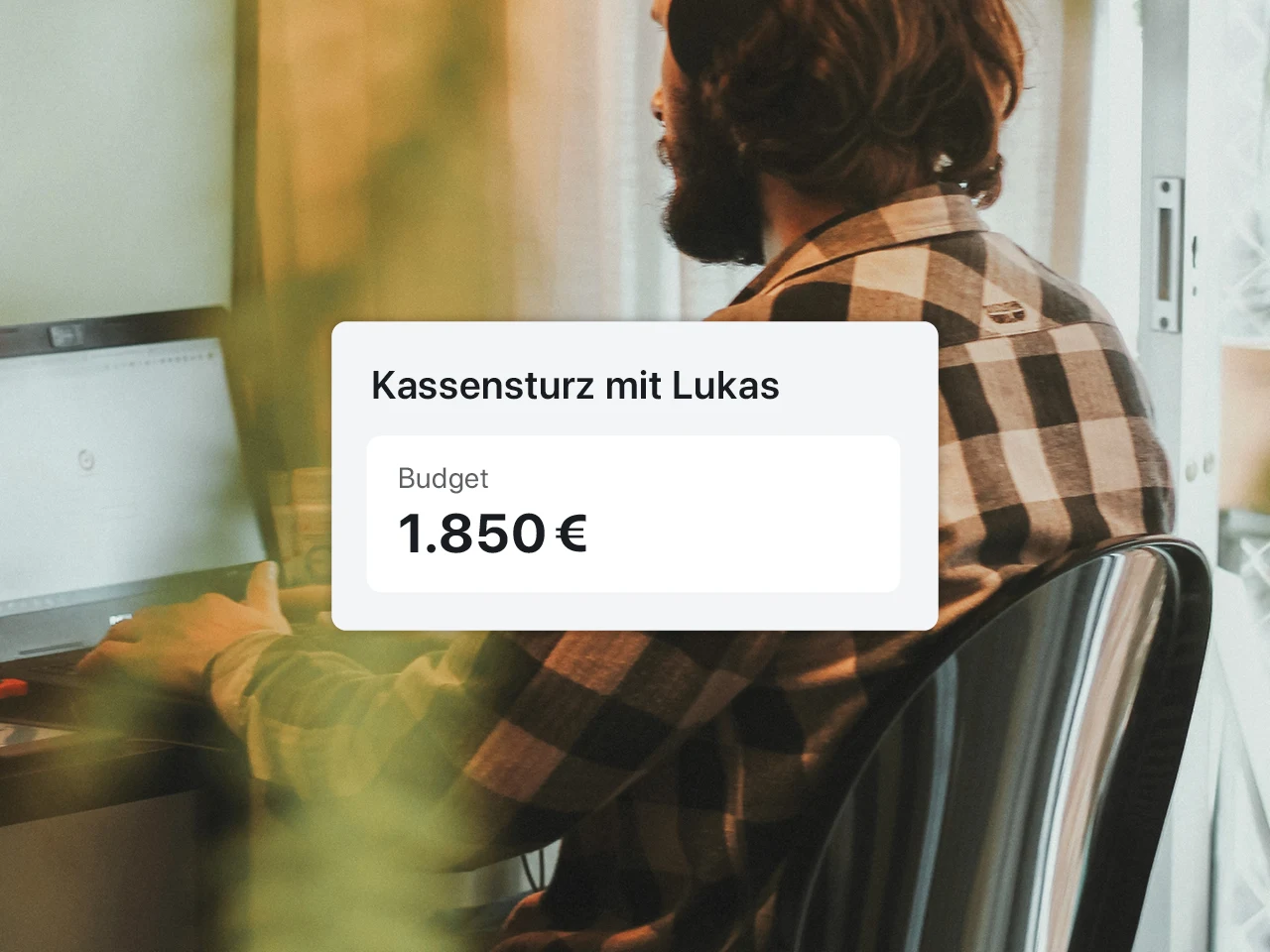 Auf dem Bild zu sehen ist ein Mann am Laptop. Darüber ist Schrift gelegt mit seinem Budget von 1.850 Euro. 
