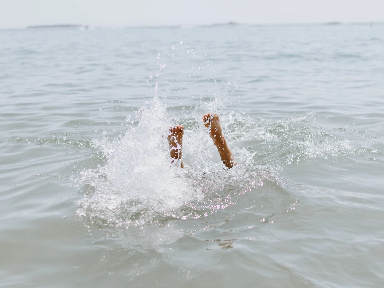 Person die ins Wasser springt
