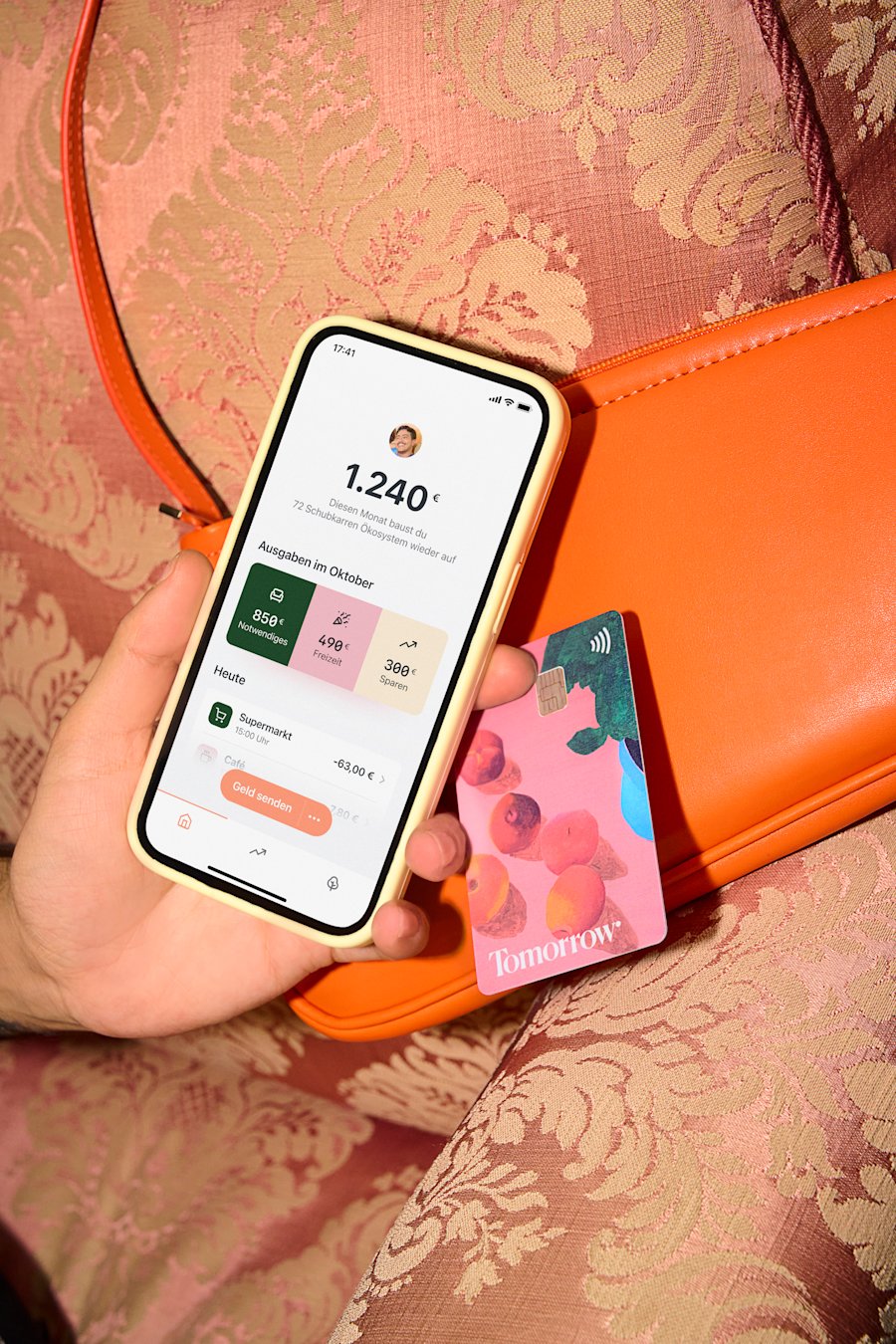 A person is holding a smartphone with the Tomorrow app open and visible on the screen.