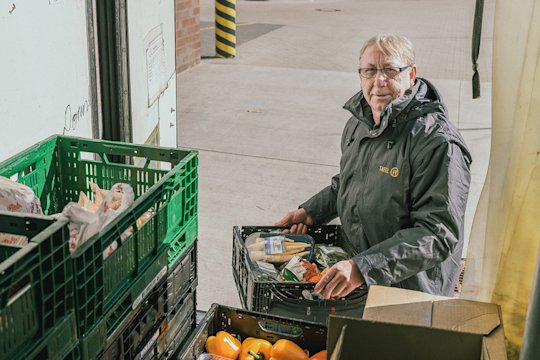 Mann mit Kiste Früchten in der Hand