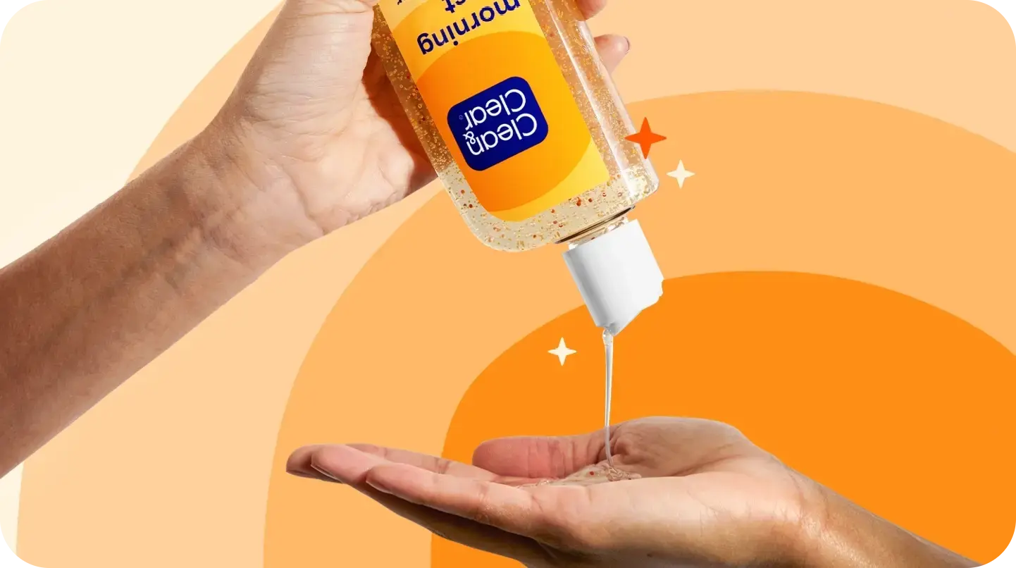 A hand pours Clear & Clean morning burst facial cleanser onto another hand against a vibrant orange, star-dotted background.