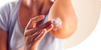 Close up image of a persons upper arm & their hand itching the skin on their arm