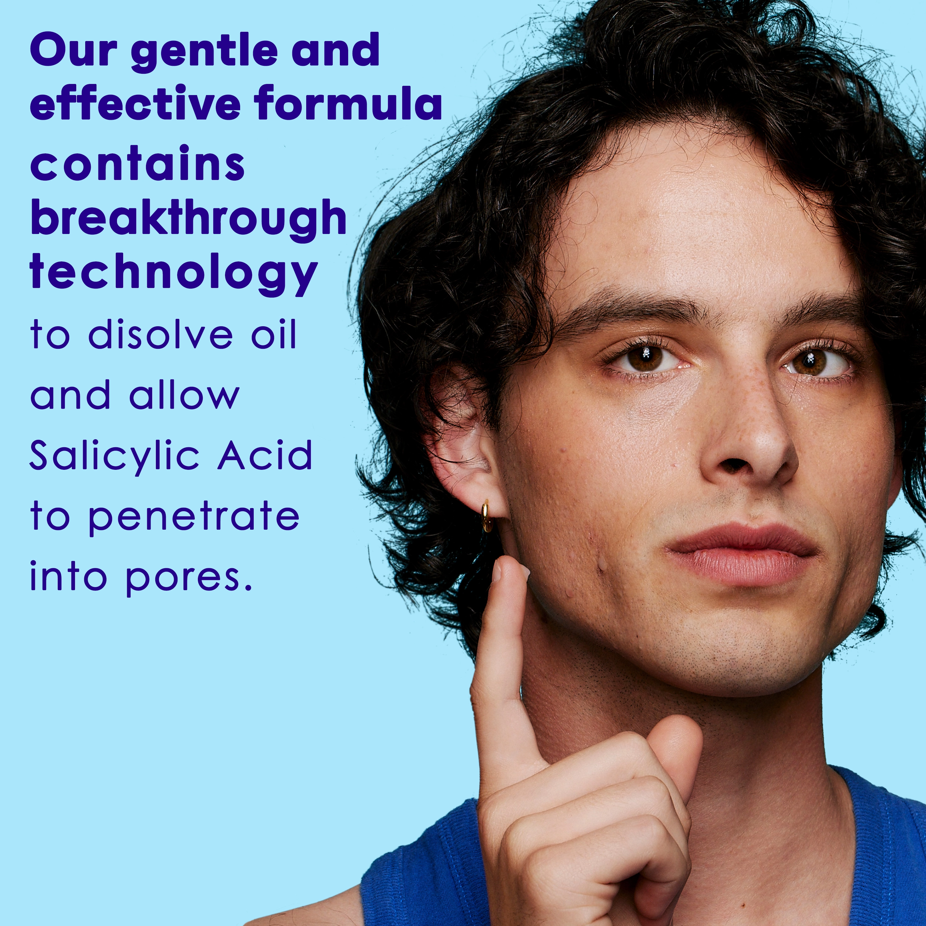 A person with curly hair touches their face against a blue background. Text reads: "Our gentle and effective formula contains breakthrough technology to dissolve oil and allow Salicylic Acid to penetrate into pores."