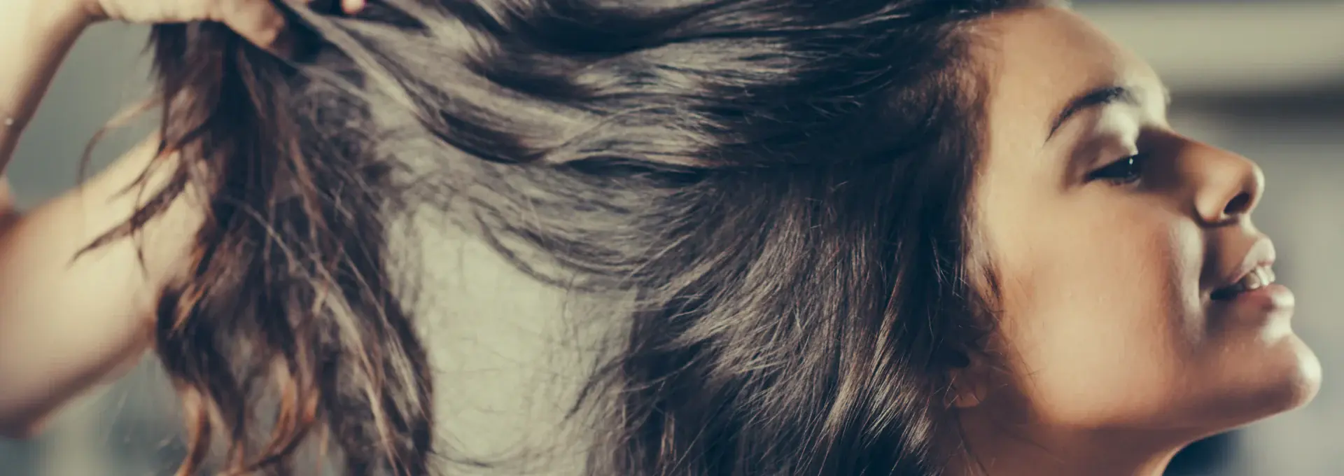 Close up of woman with long brown hair getting her hair styled