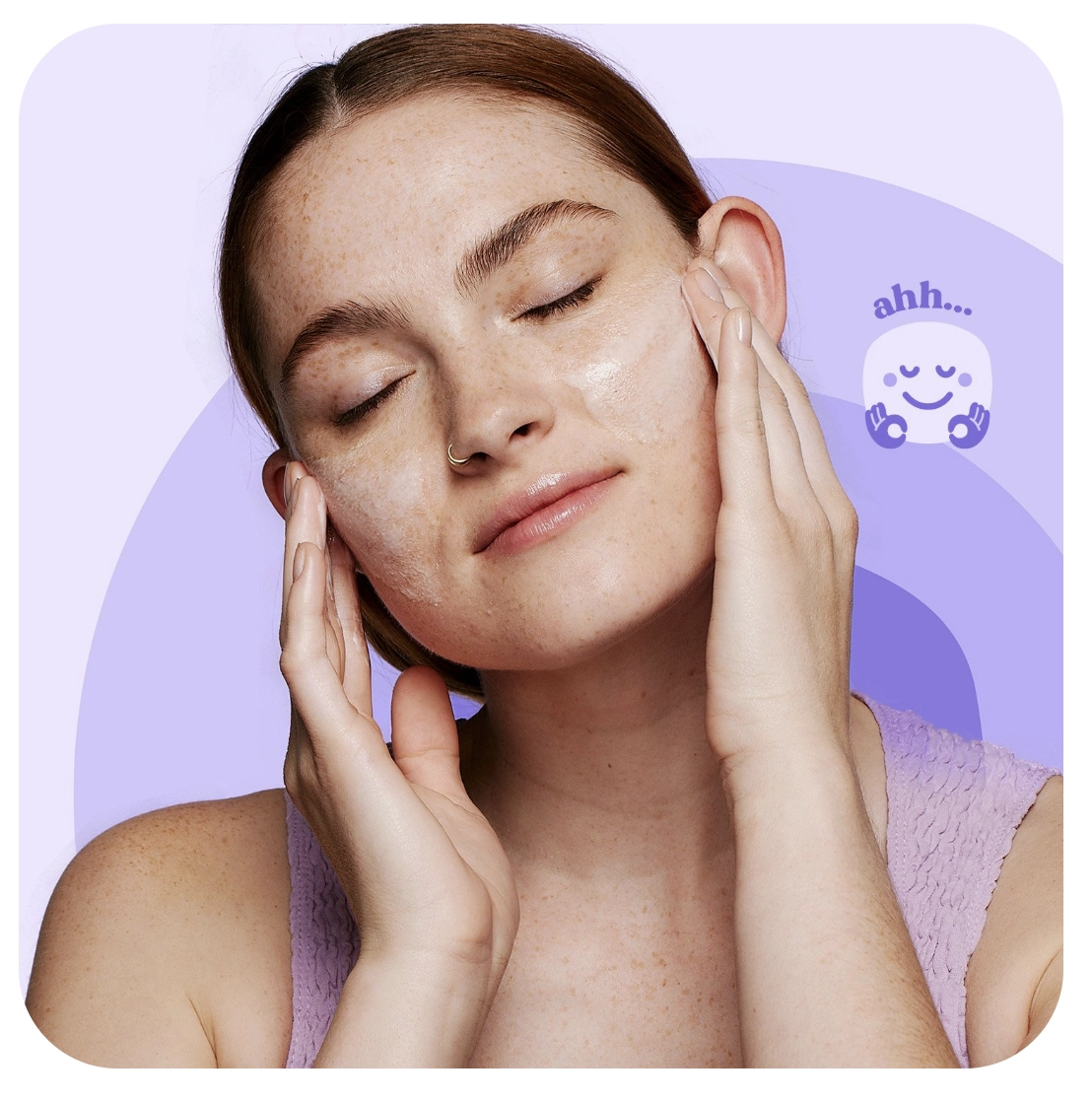 A person gently massages their face with closed eyes, creating a soothing expression. The purple background features a small smiling icon with the word "ahh..." nearby.