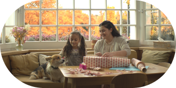 Smiling mother and daughter with pet dog.