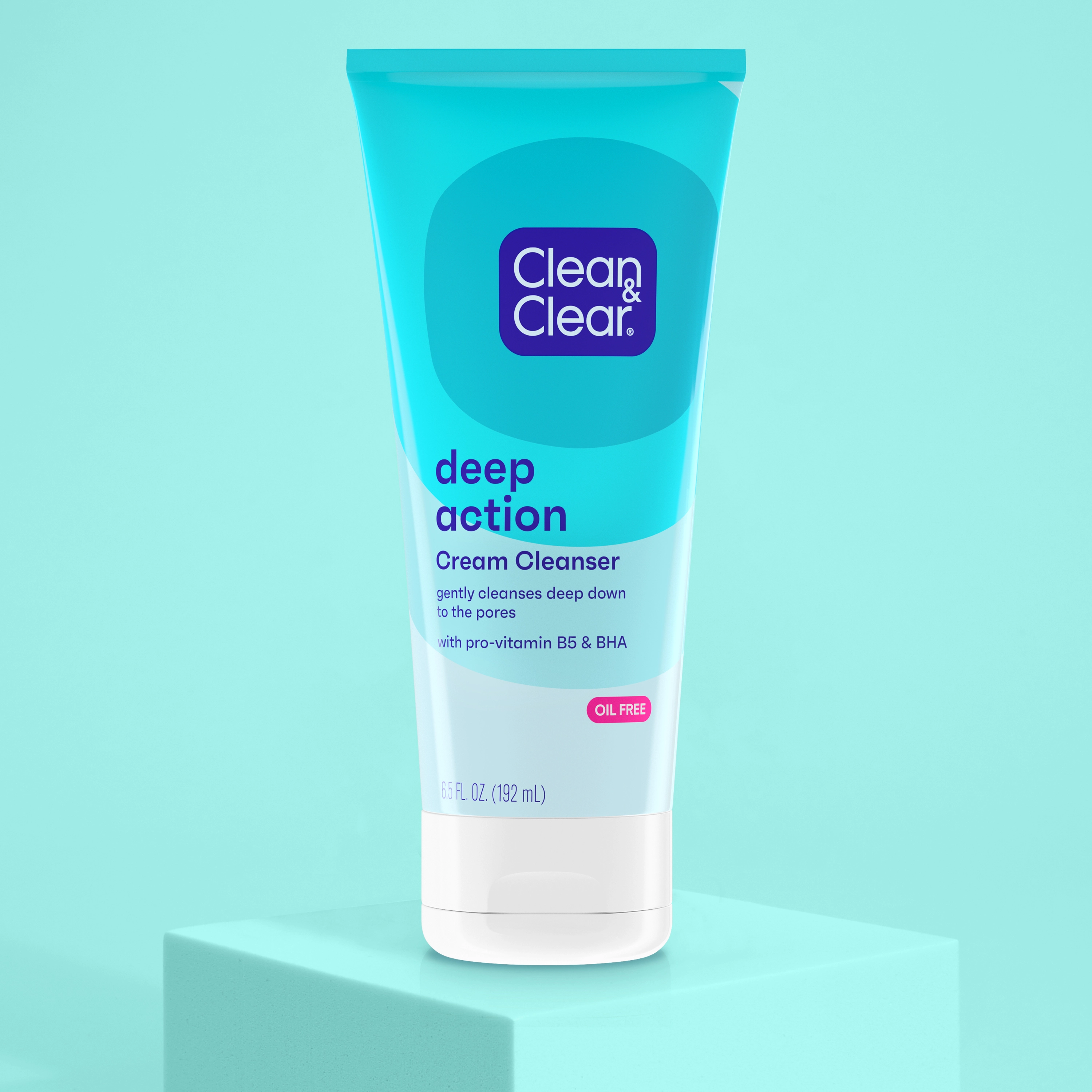 A tube labeled “Clean & Clear deep action Cream Cleanser” stands upright on a light blue surface. It claims to "gently cleanse deep down to the pores" with "pro-vitamin B5 & BHA."