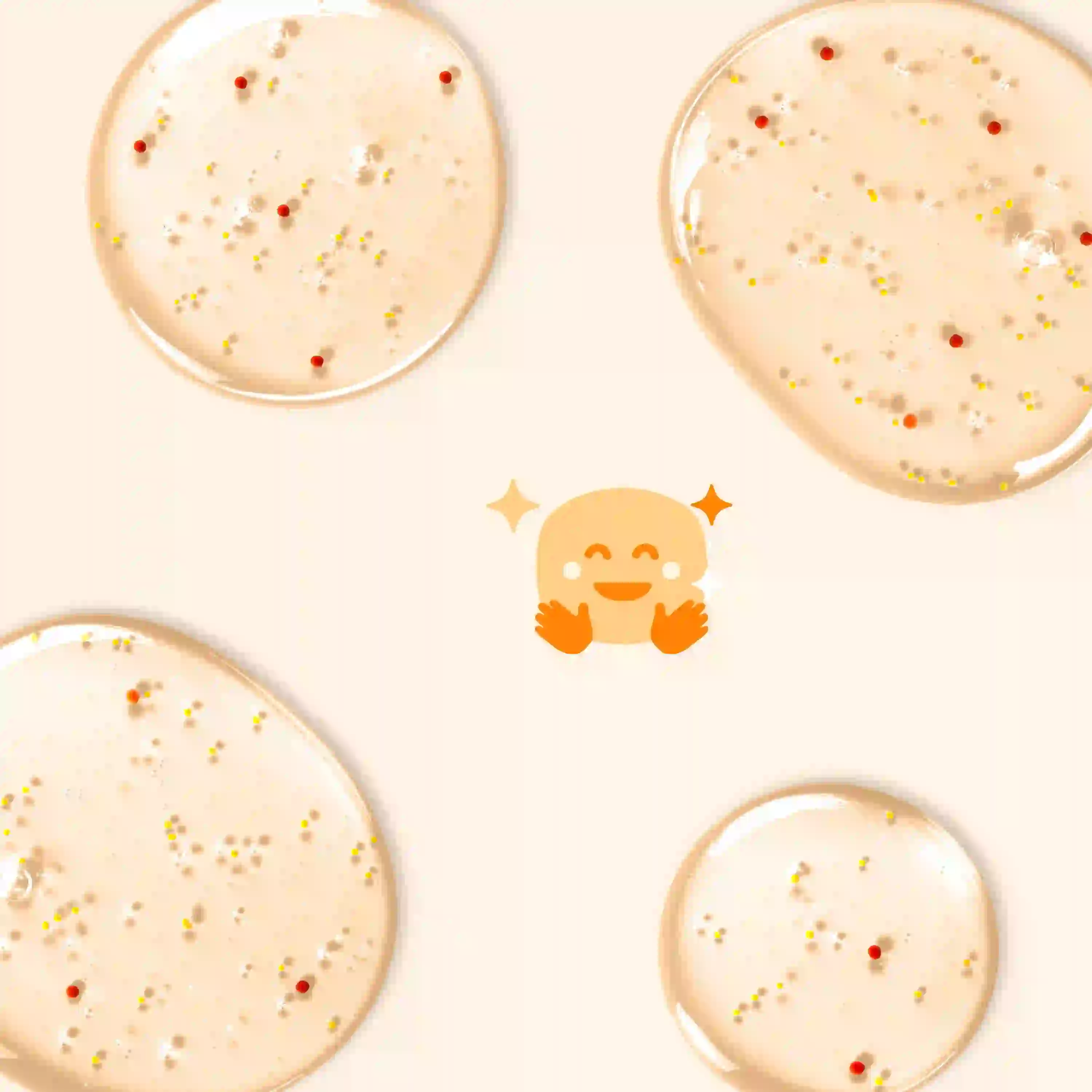 Pale beige gel droplets with small colorful beads scattered on a light background, surrounding a bright, smiling emoji with sparkling eyes and orange hands in an embracing gesture.