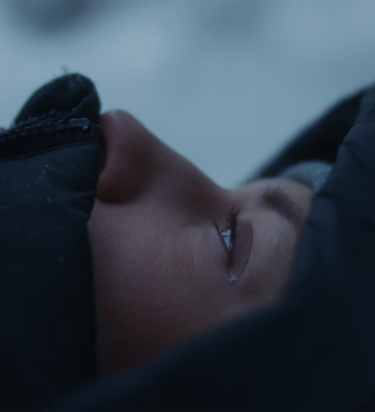 Maria Granberig lying in the snow looking up with tears in her eyes.