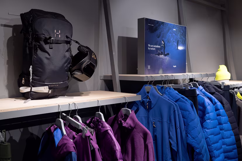 Image of clothes hanging on racks in brand store