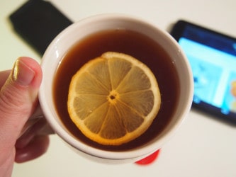 a put of tea with a slice of lemon on top
