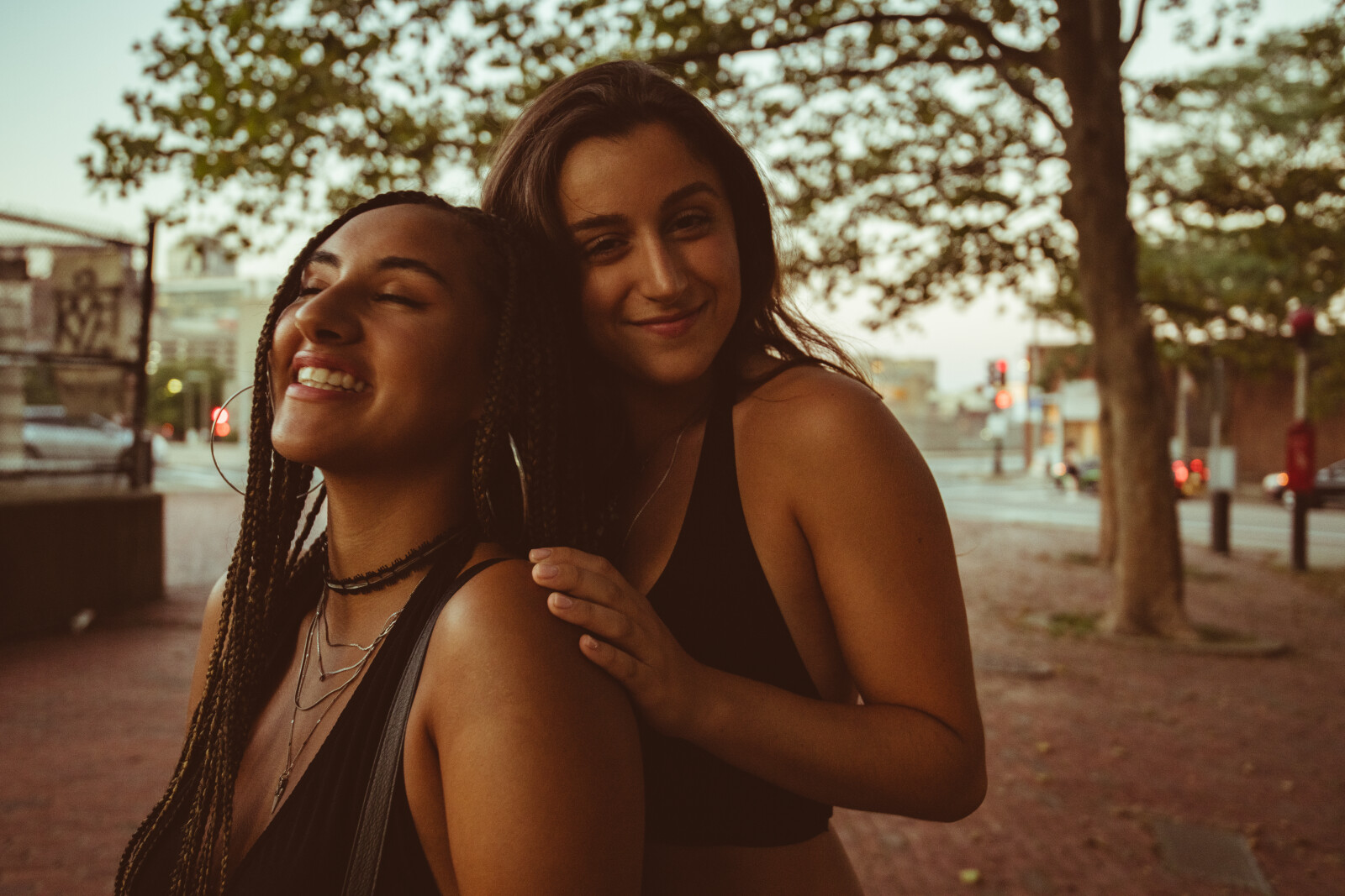Two women hugging front to back at a park