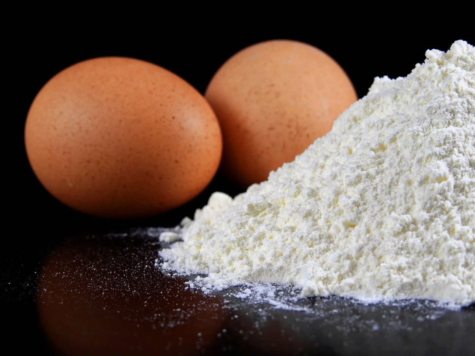 A pile of powder with two eggs behind it. 