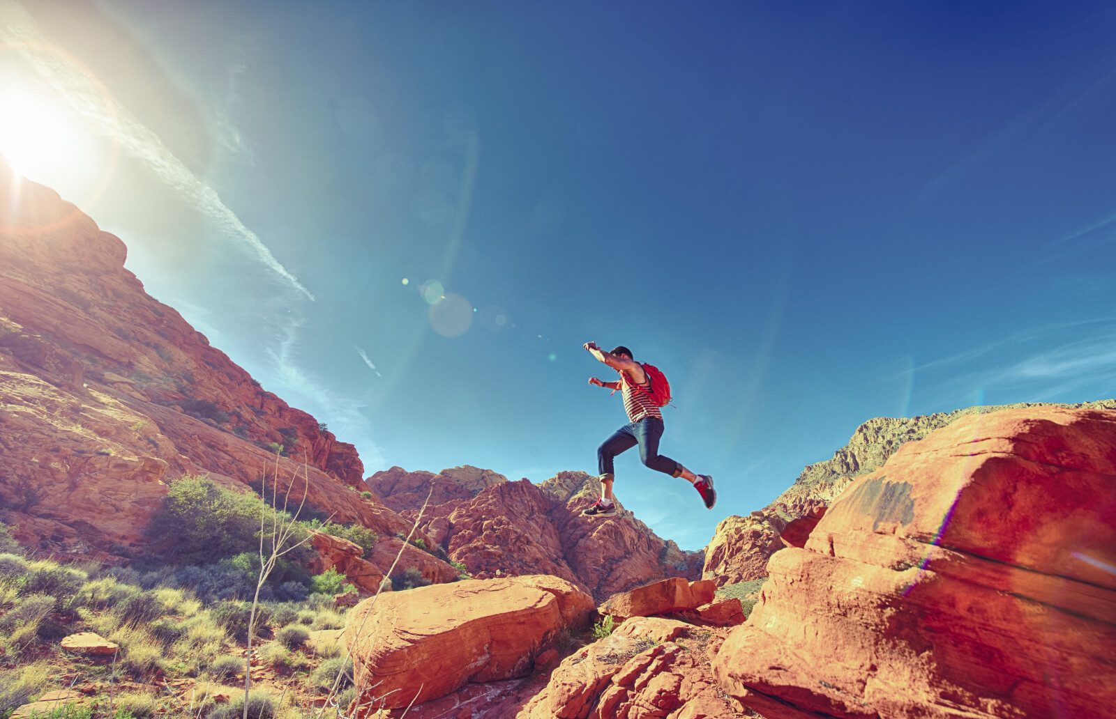 man jumping over rocks on a mountain 