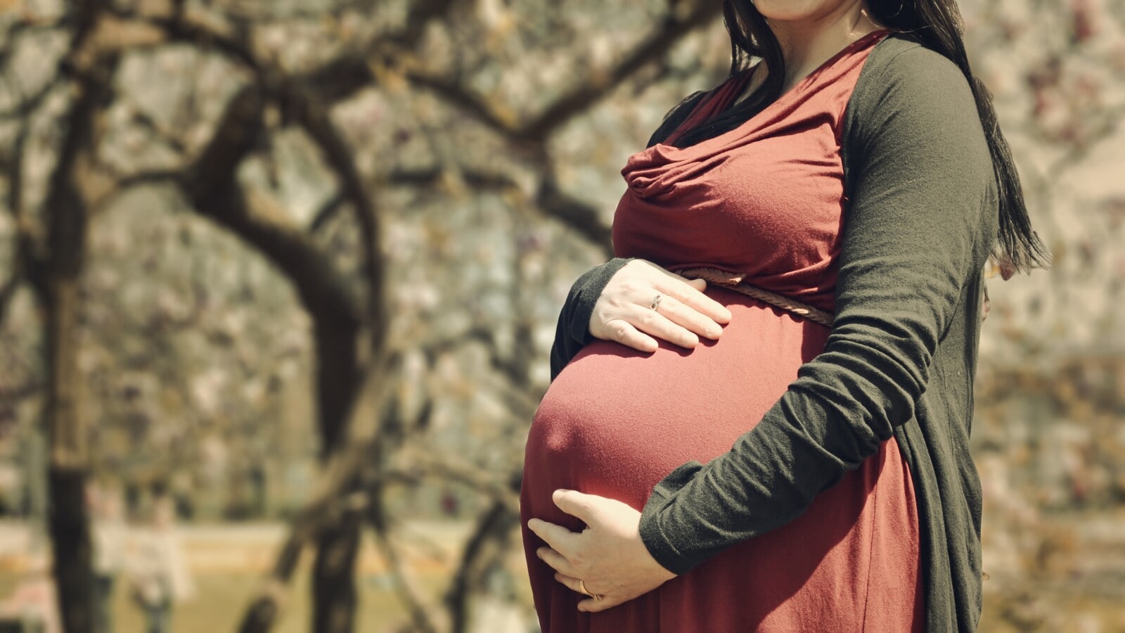 A pregnant person holding their stomach