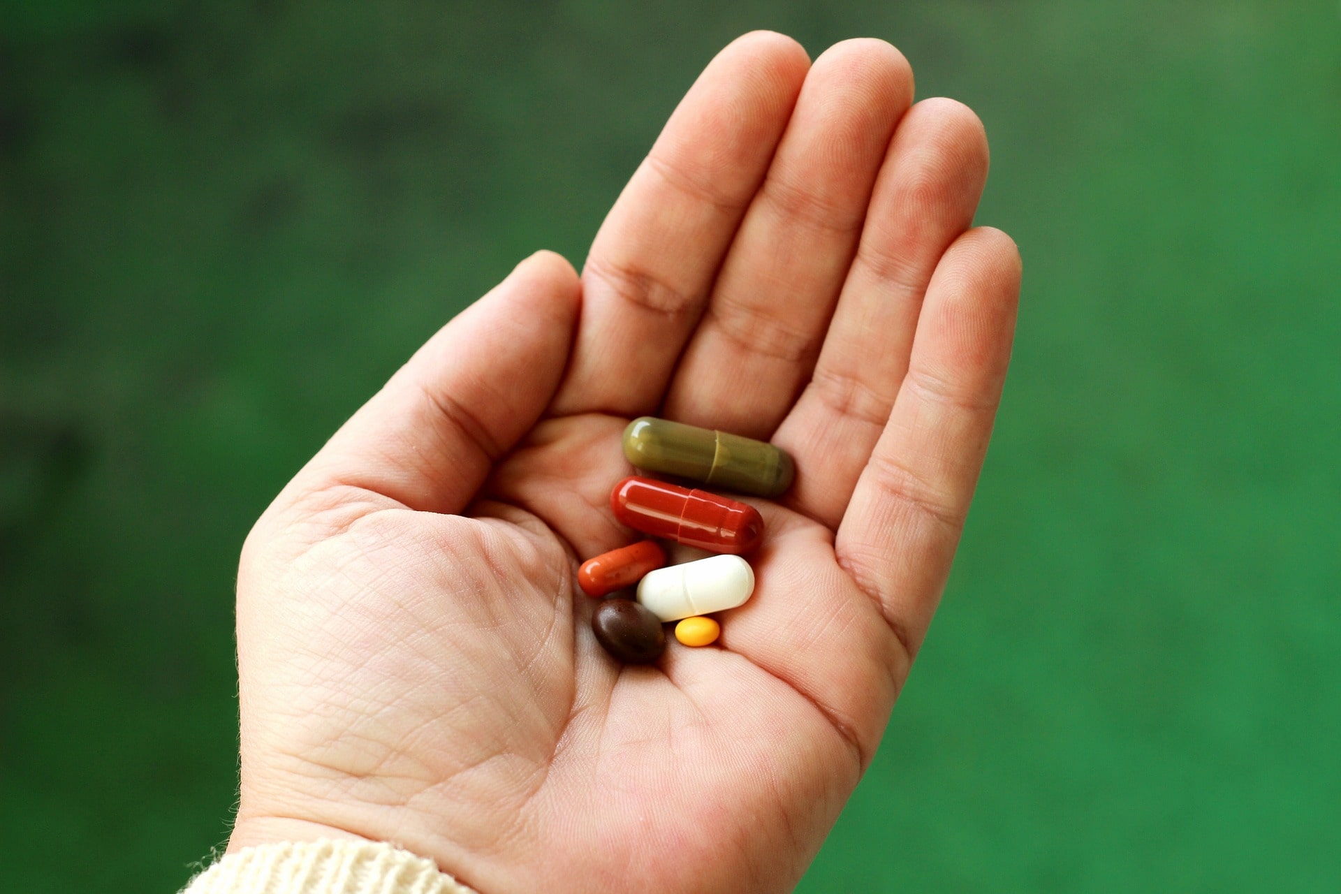A person holding various types of supplements. 