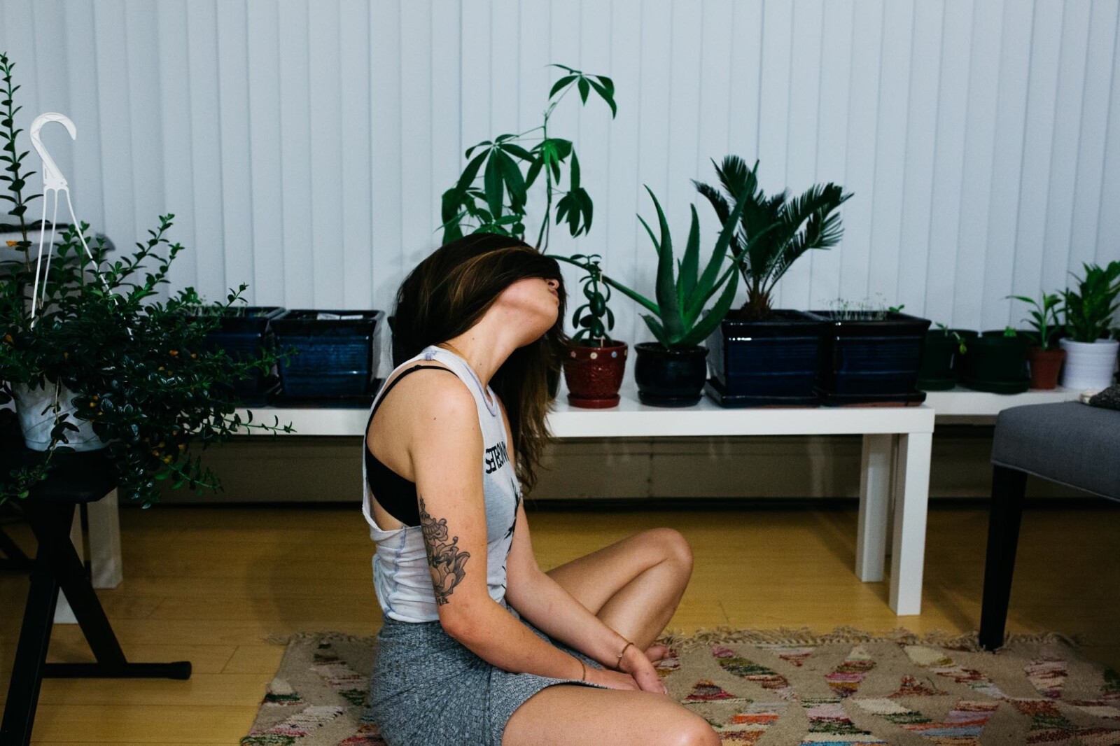 woman sitting on yoga mat, relaxing and stretching her neck 
