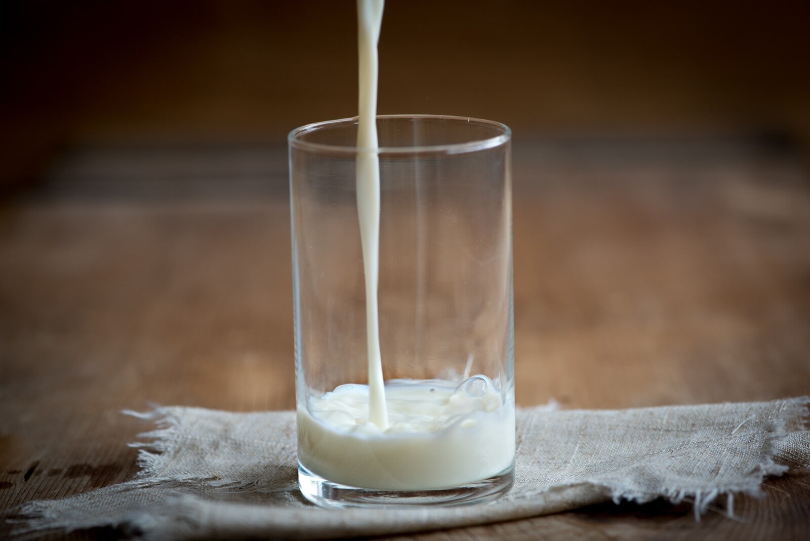 milk being poured into a glass 