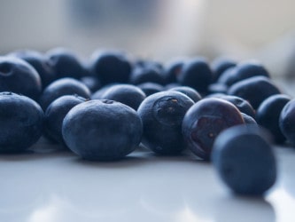 side photo of blueberries on a white countertop 