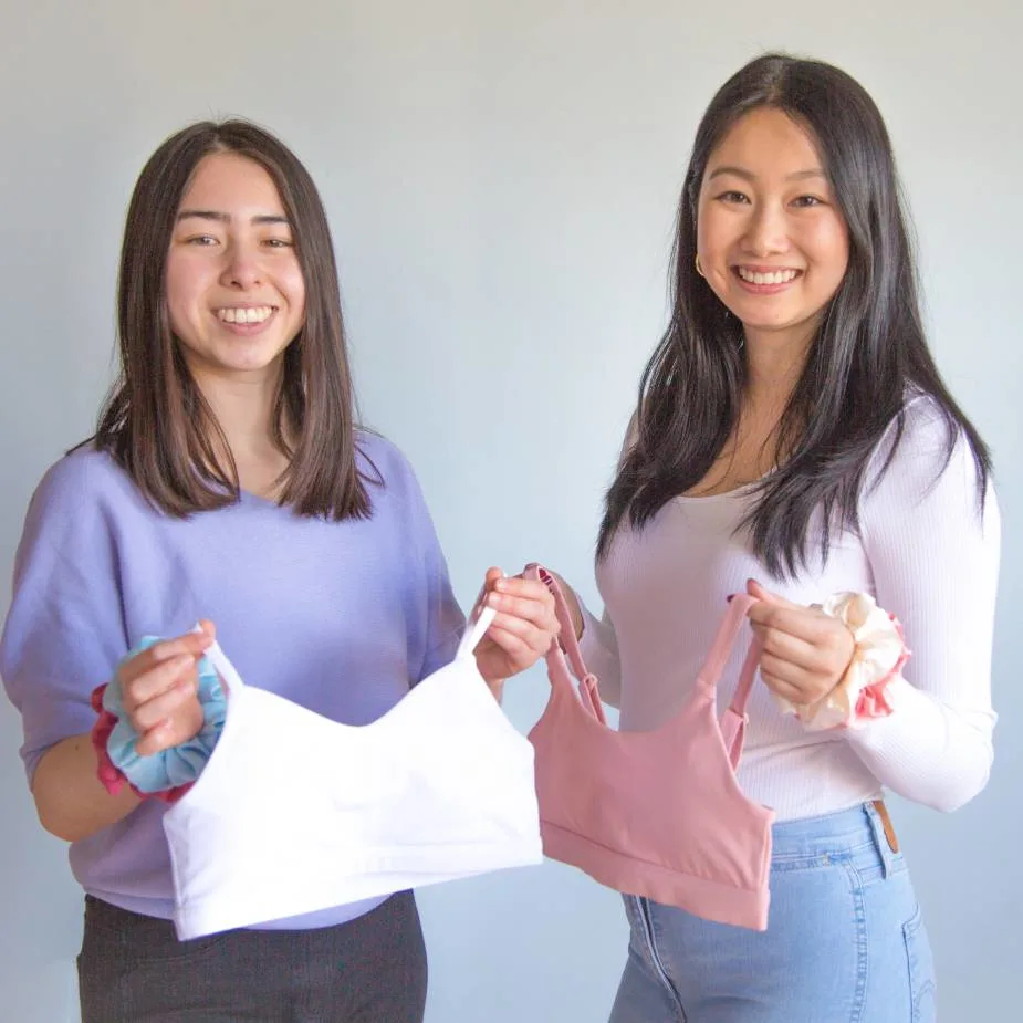 Apricotton entrepreneurs smile while holding their best seller product in white (left) and pink (right)
