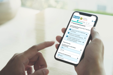 Person bedient ein Smartphone, das eine Finanzchef24-Seite mit einer Abfrage zu IT-Sicherheitsvorkehrungen beim Abschluss einer Cyberversicherung anzeigt. Es werden Fragen zur Nutzung von Antivirenprogrammen und zur Datensicherung gestellt.