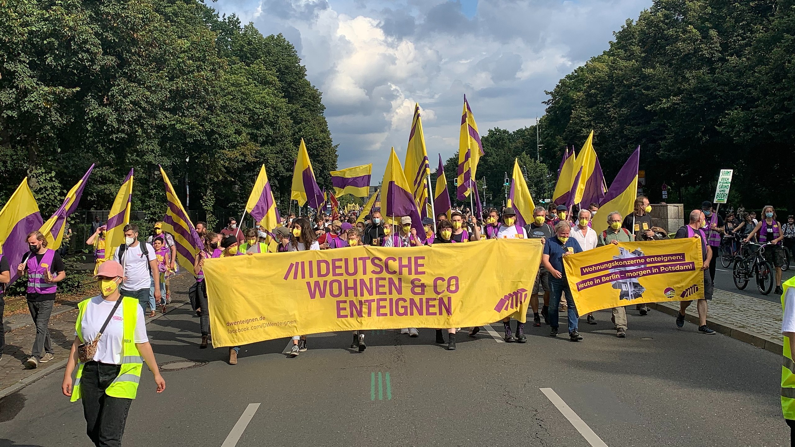 Protesters carrying flags and banners at a Deutsche Wohnen & Co Enteignen demonstration