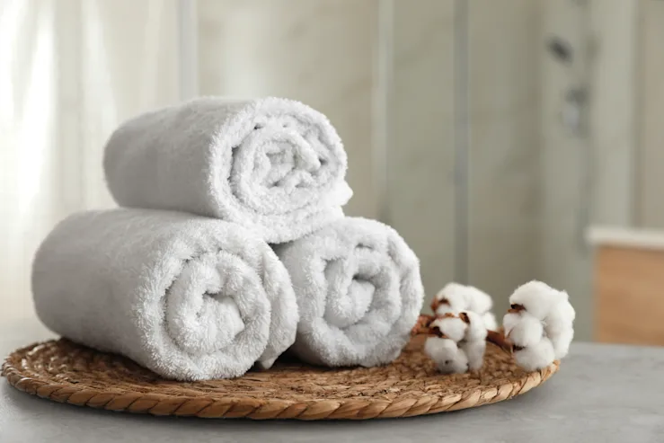 Rolled White Towels Stacked On A Wooden Tray