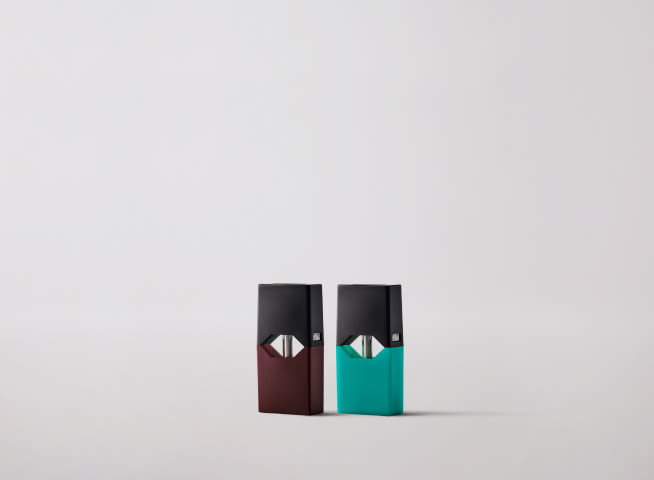 Close-up of two JUULpods in Menthol and Virginia Tobacco flavors against gray background.