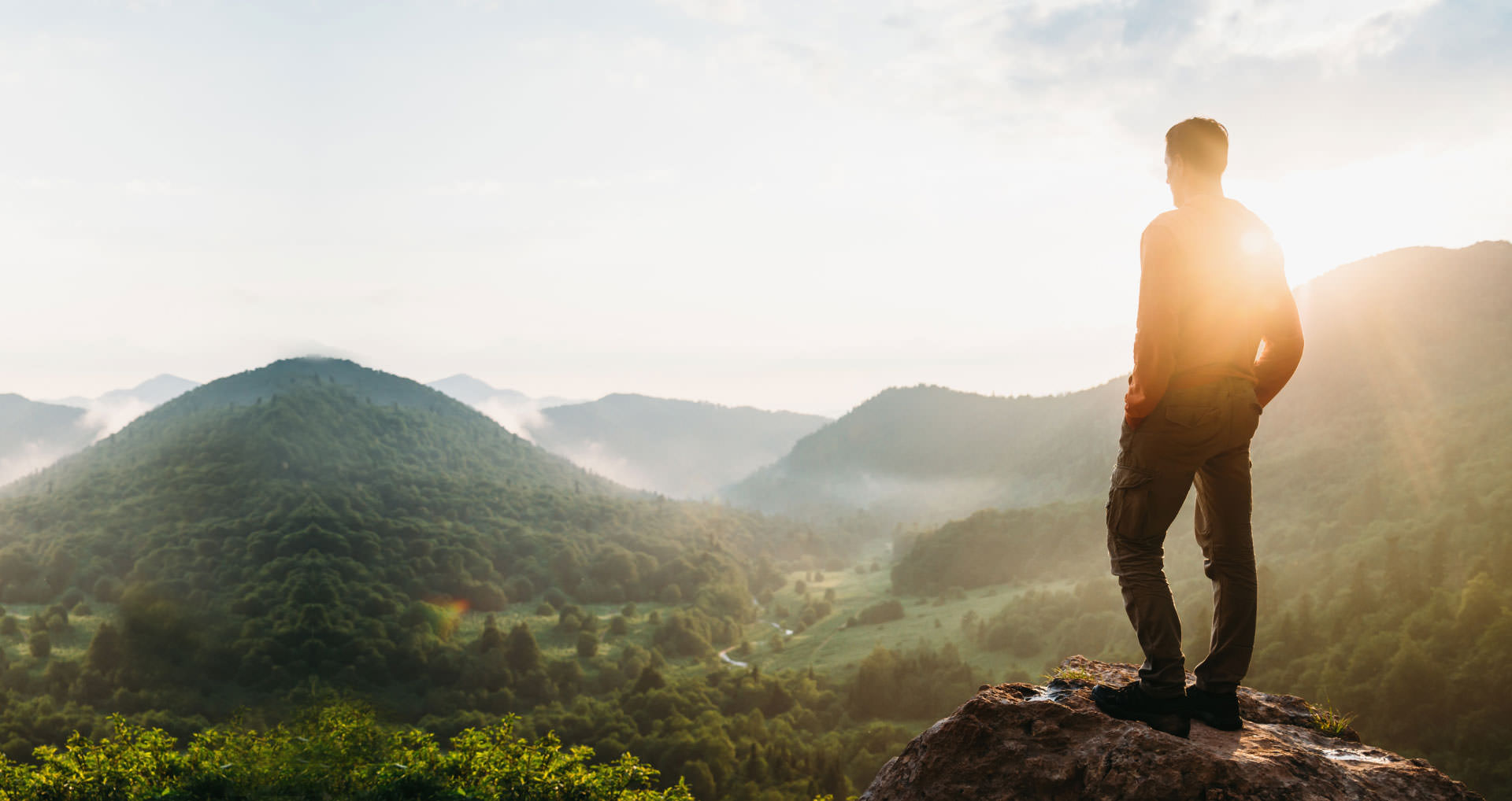 hiker-looking-out-over-green-hills-i-screen