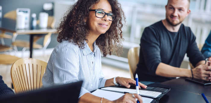 Image of a female manager discussing team action plan with colleagues