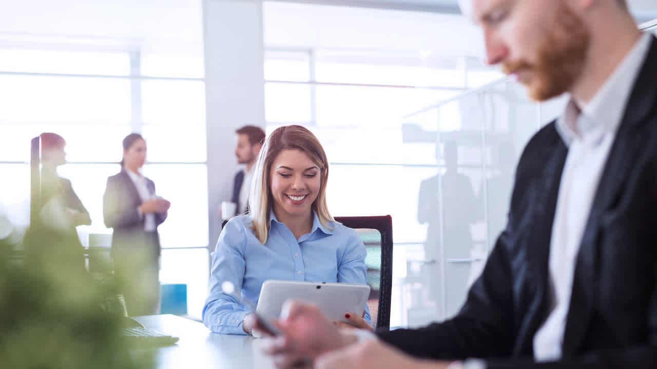 Image of two employees filling out surveys on tab and computer