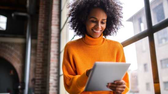 Woman in orange sweater with ipad