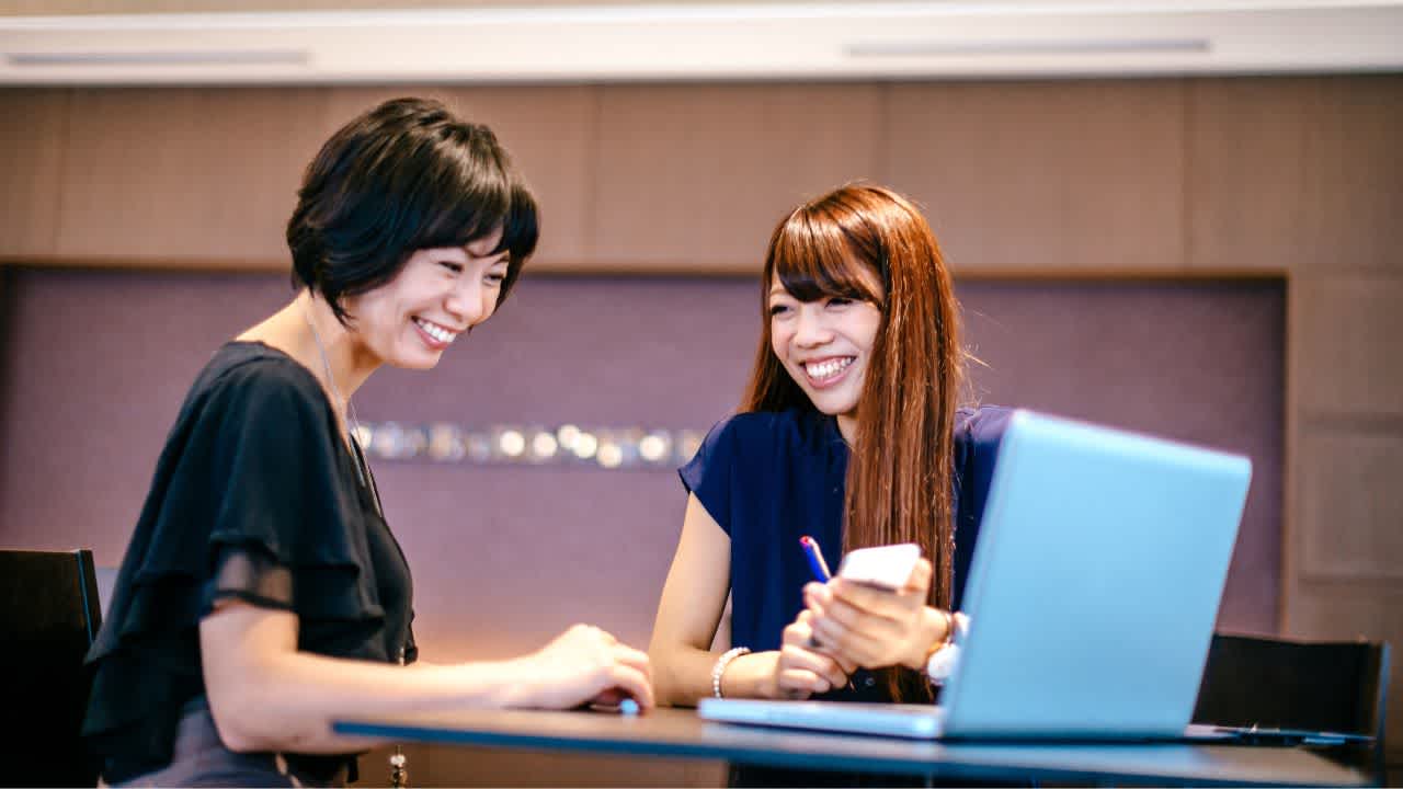 Two women discussing how to implement a 360 feedback system