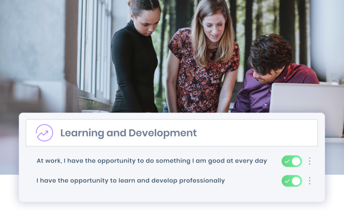 Three colleagues in front of laptop discussing employee development