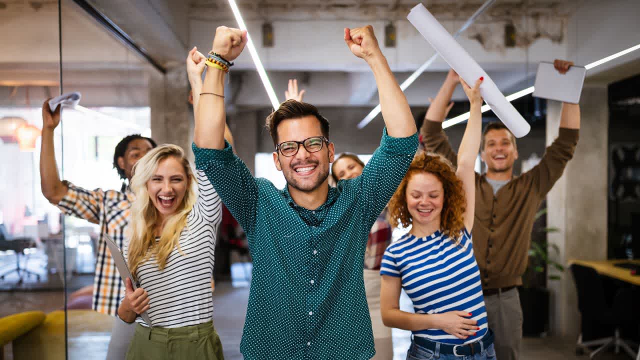 Positive psychology in the workplace illustrated by happy team