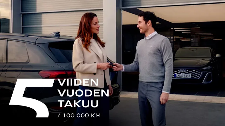Audi 5 vuoden takuu – mies ojentaa naiselle auton avaimet auton edessä.