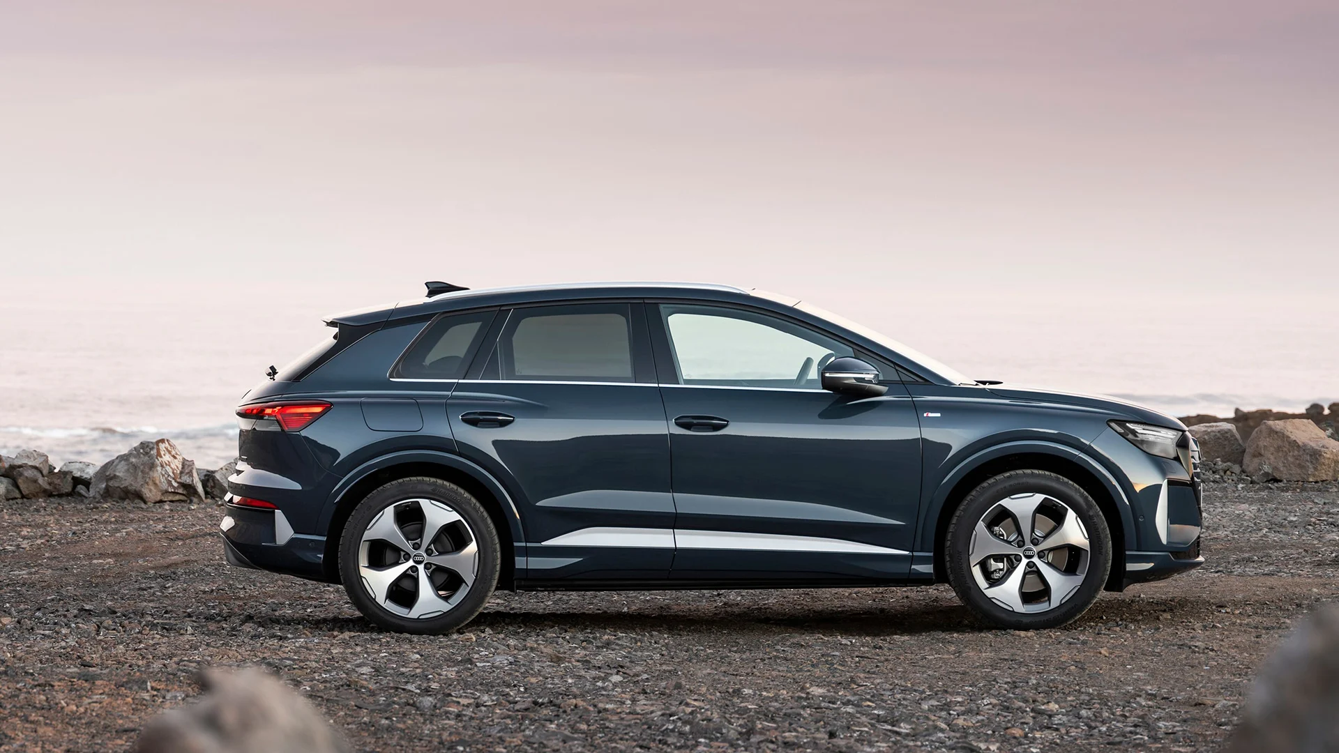 Audi Q4 e-tron rannalla auringonlaskun aikaan.