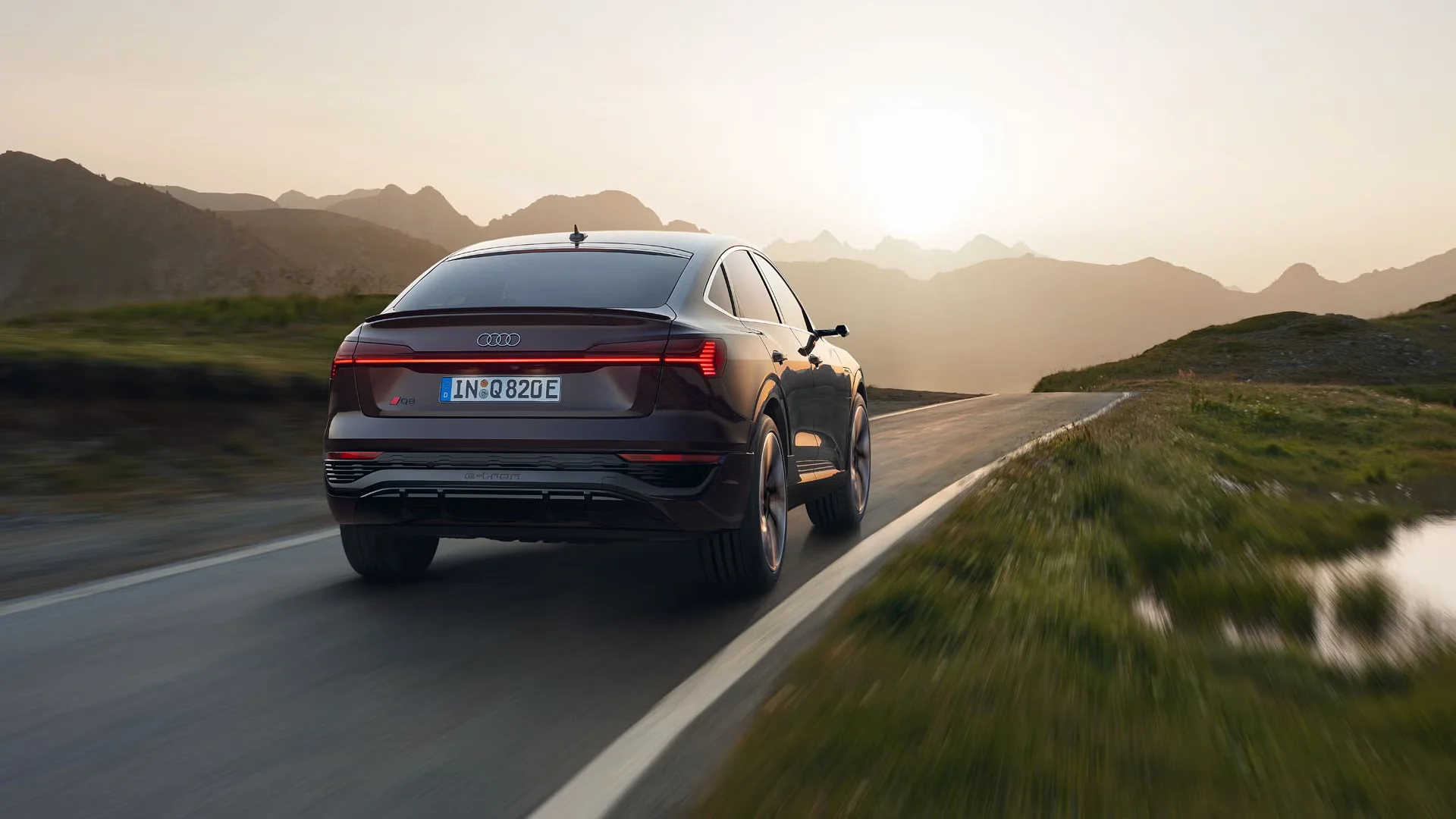 Audi ajaa sumuiselle iltatiellä auringonlaskua kohden.