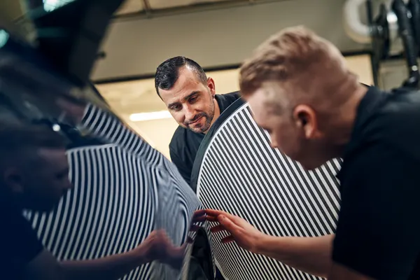 K-Auton korimekaanikko arvioimassa pientä lommoa