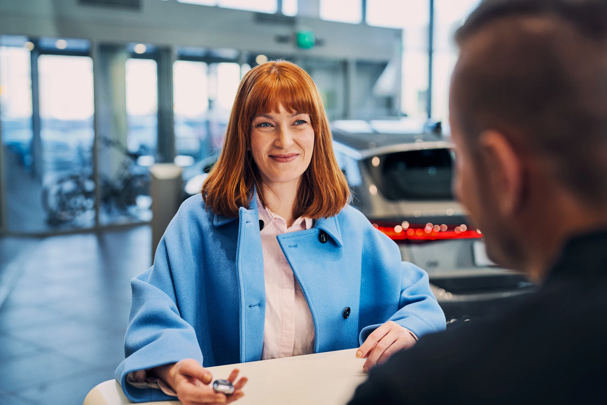 Nainen hakee autoa K-Autolta varauksen yhteydessä.