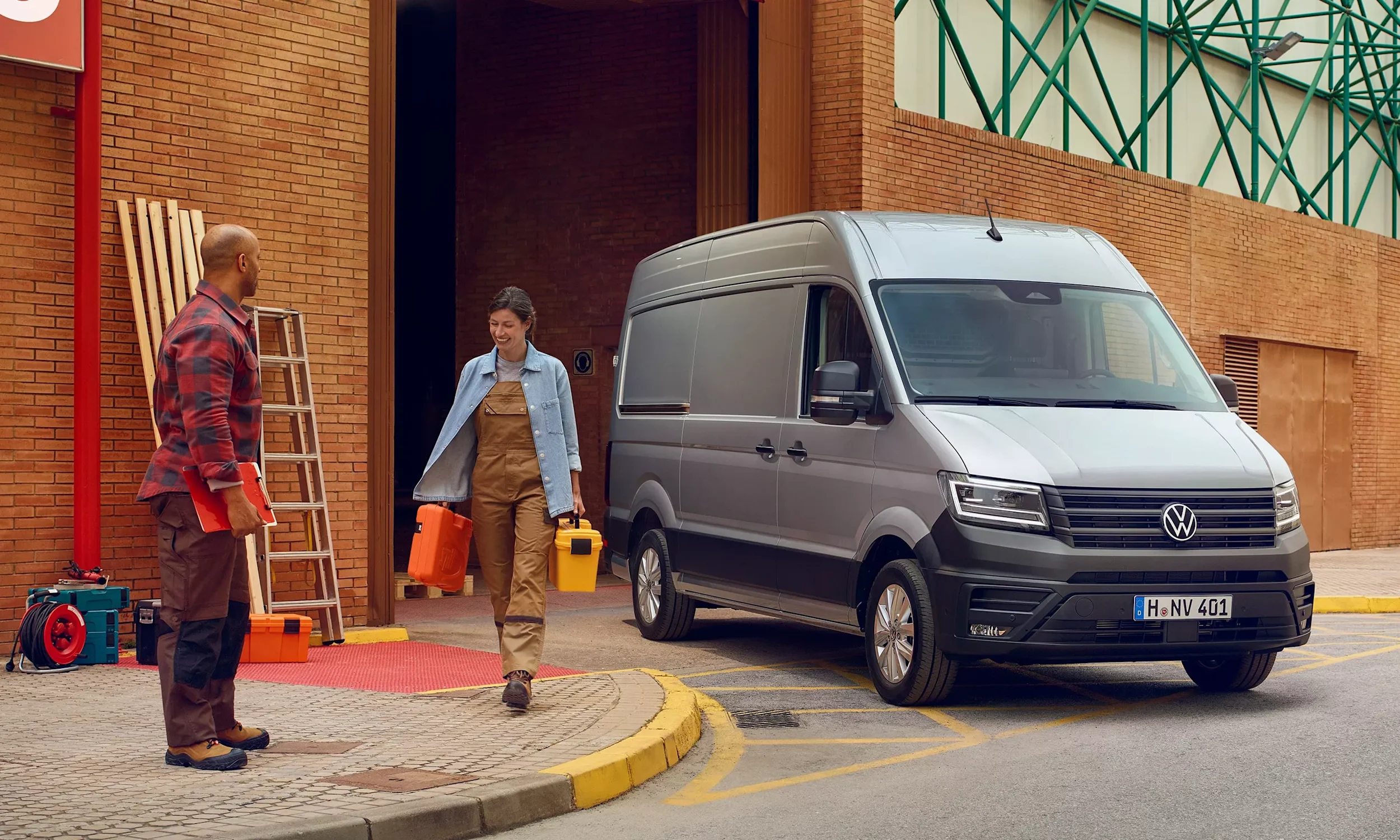 Harmaa Volkswagen Crafter parkissa rakennuksen edessä.