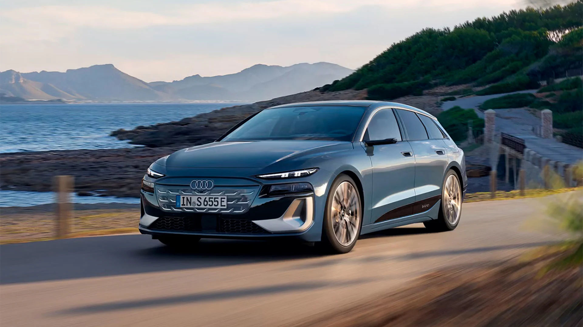Sininen Audi S6 e-tron Avant ajossa rantatiellä.