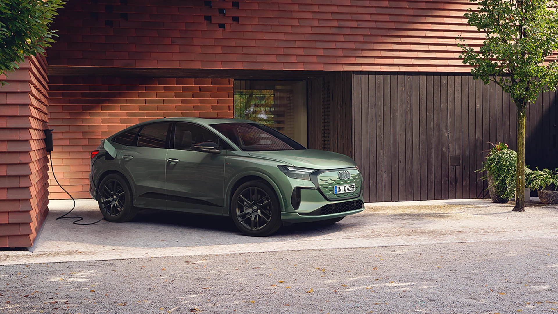 Audi Q4 e-tron Sportback lataamassa talon pihalla.